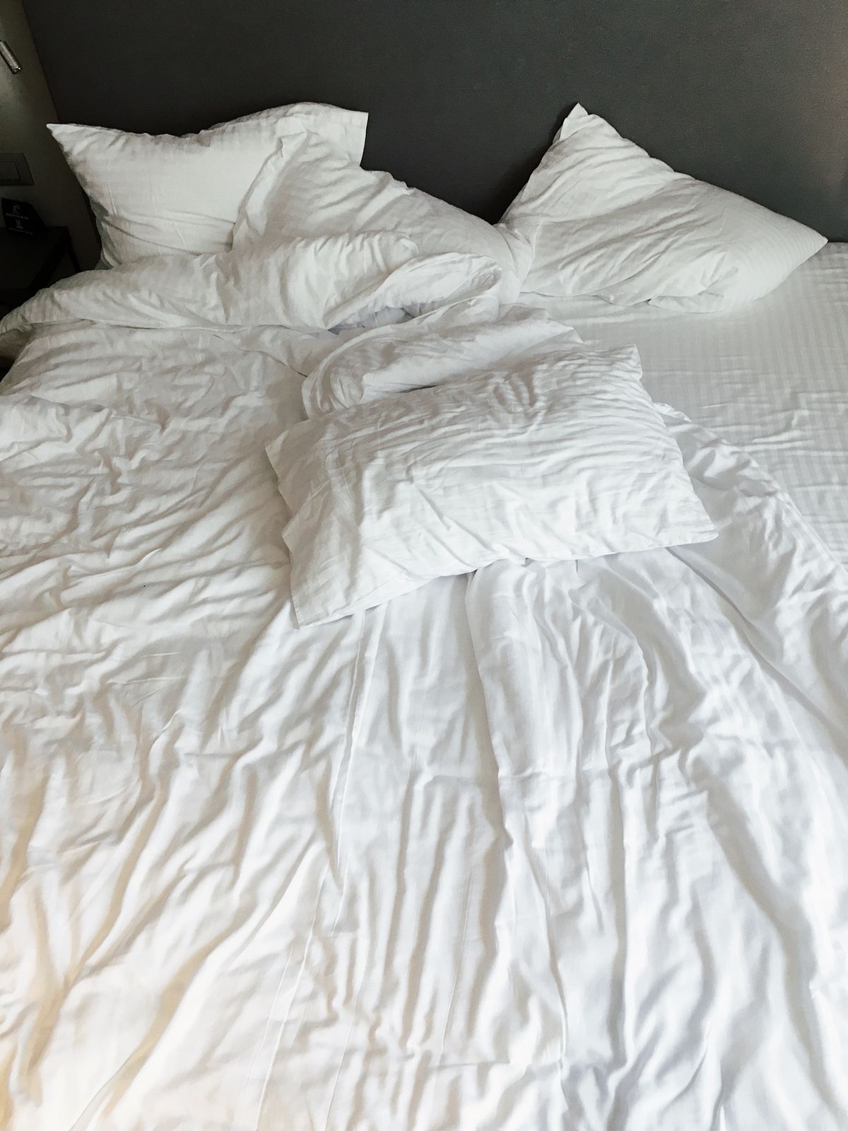 Ropa de cama blanca y almohadas en un dormitorio moderno
