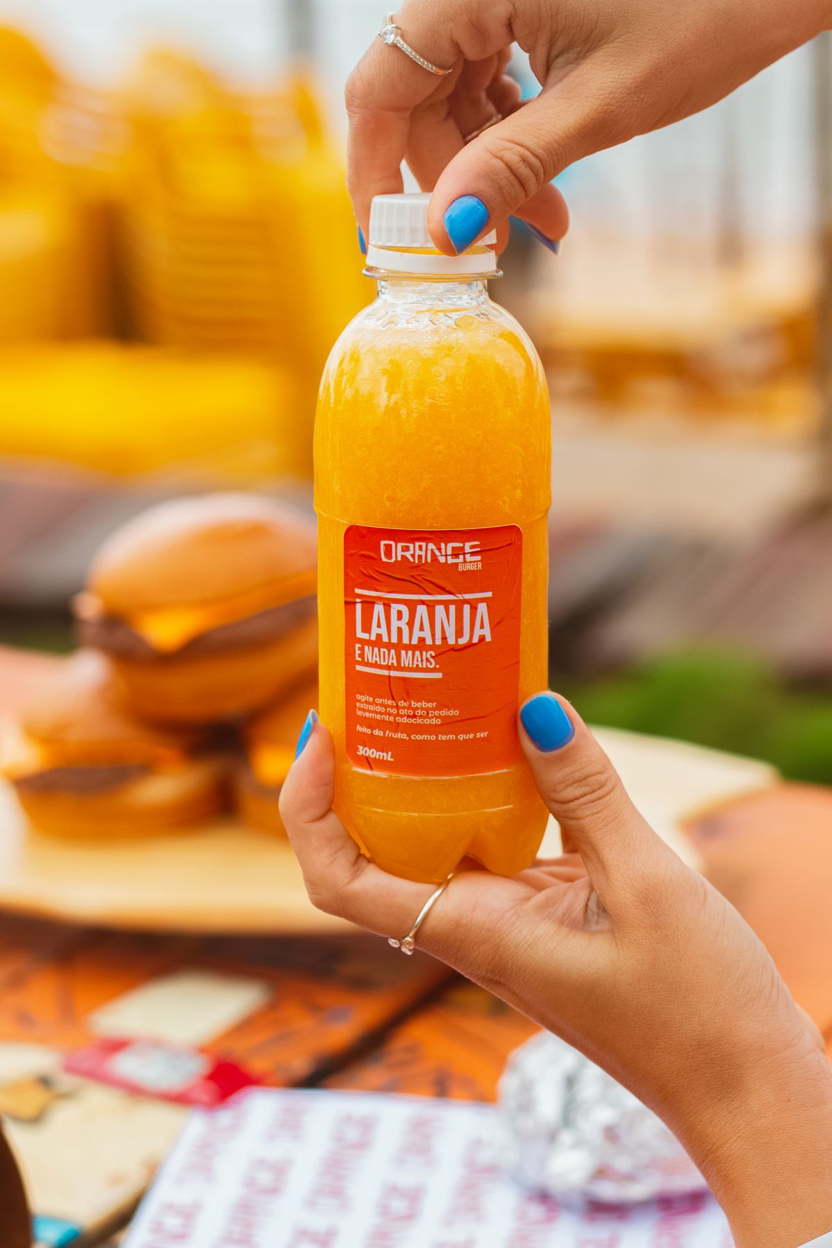 Manos sosteniendo una botella de zumo de naranja