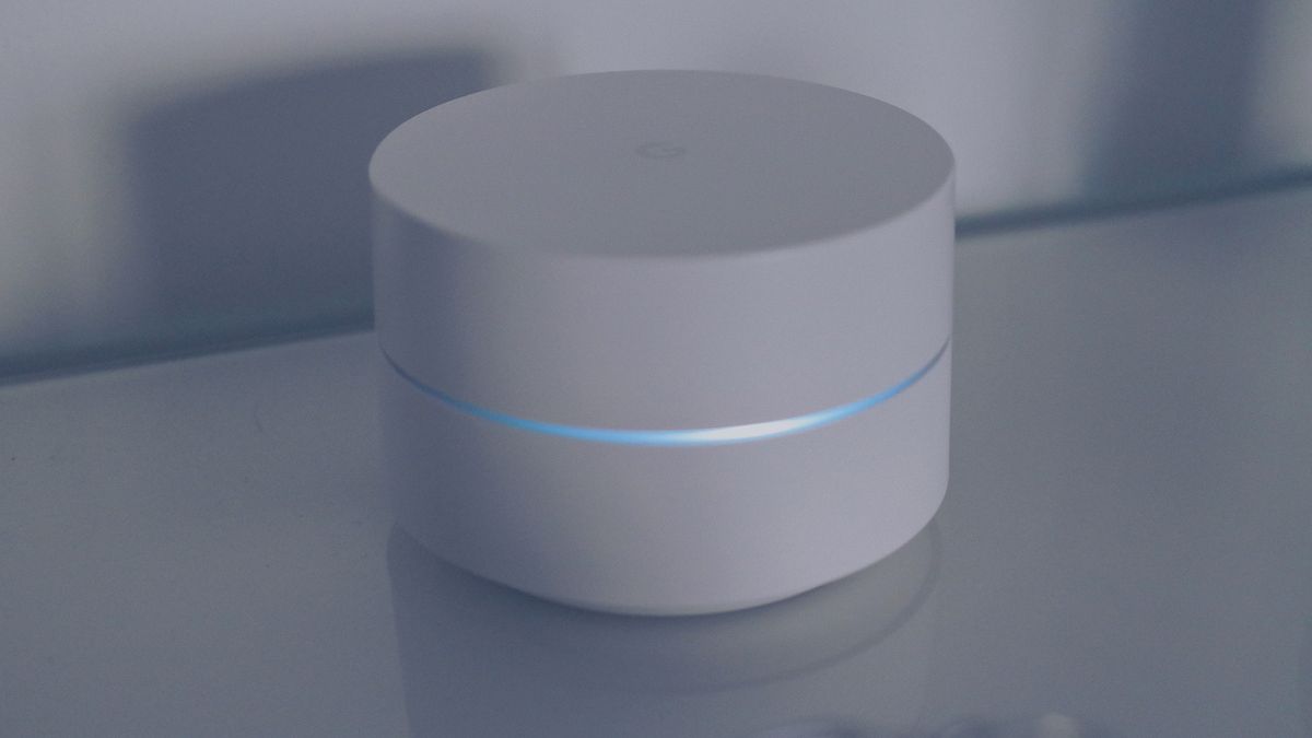 Hub Matter o punto de acceso domótico blanco de Google con anillo de luz azul sobre una superficie reflectante