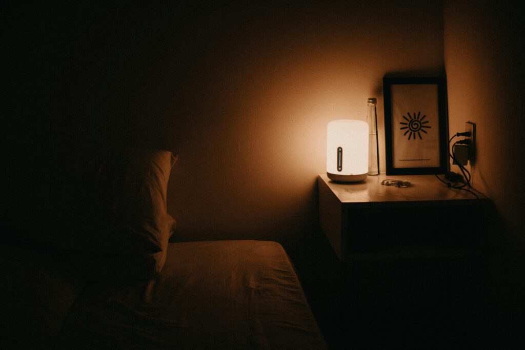 lámpara de cabecera con luz cálida en dormitorio