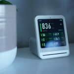 monitor de sueño en mesita de noche junto a cama