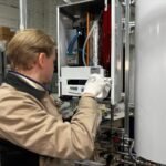 Técnico instalando una bomba de calor para agua caliente