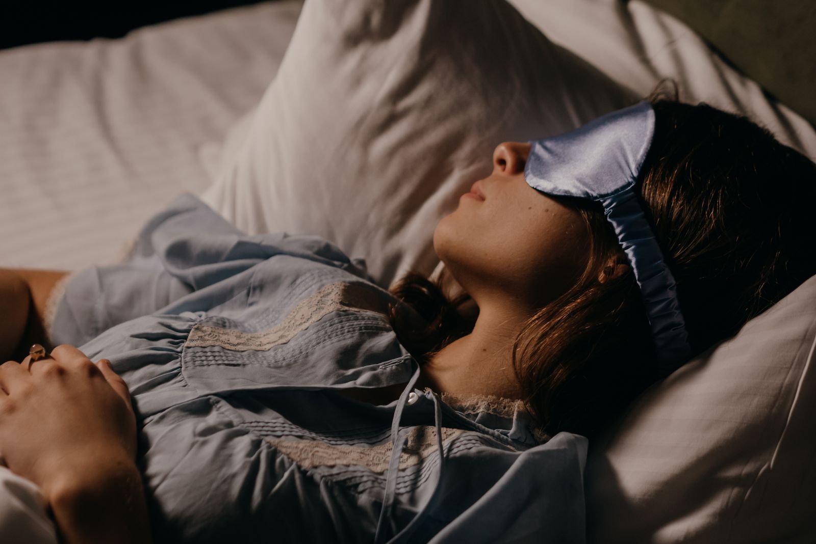 persona dormida usando antifaz en la cama