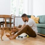 hombre acariciando a su perro en el salón