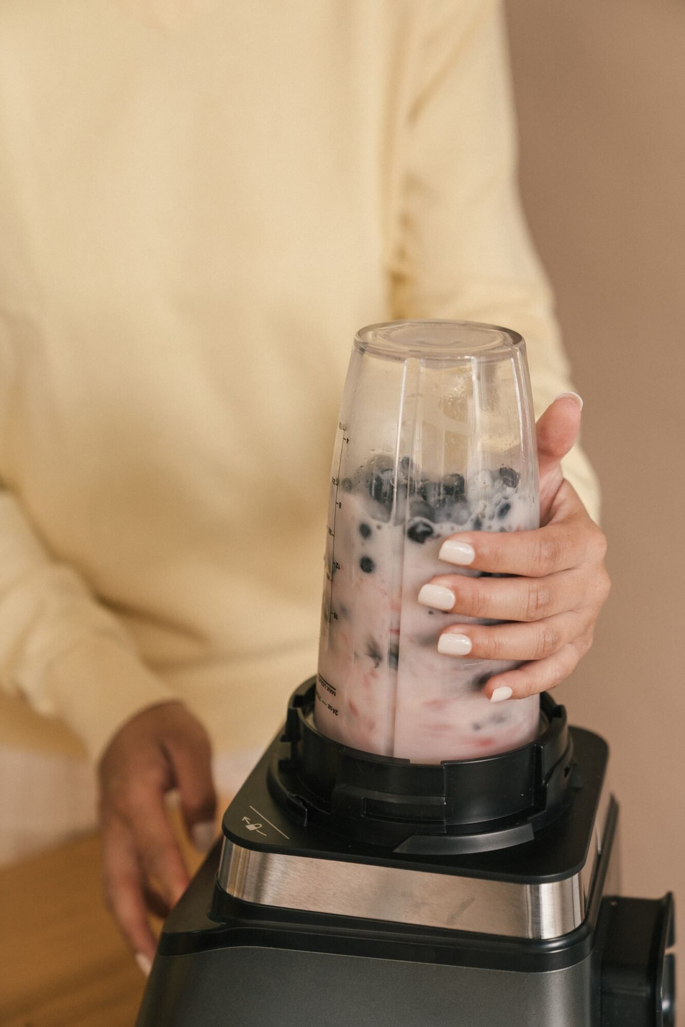 persona usando un minipimer para hacer un batido