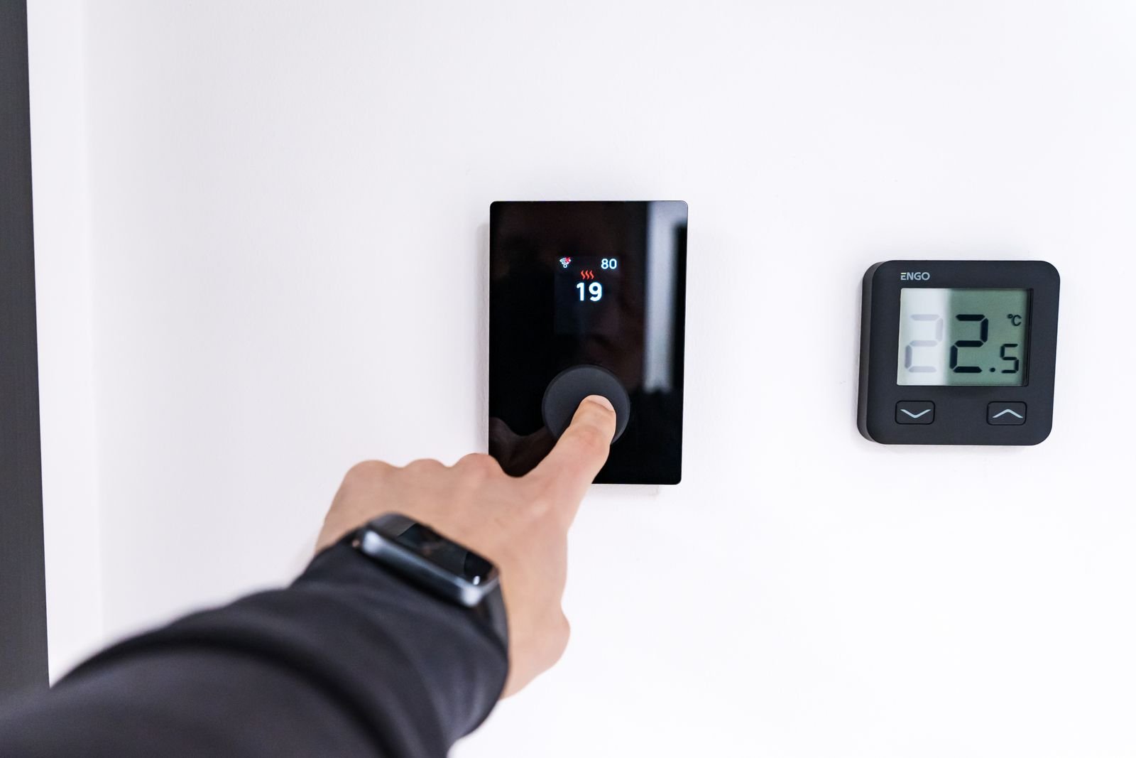 Panel de control táctil de calefacción junto a un termostato