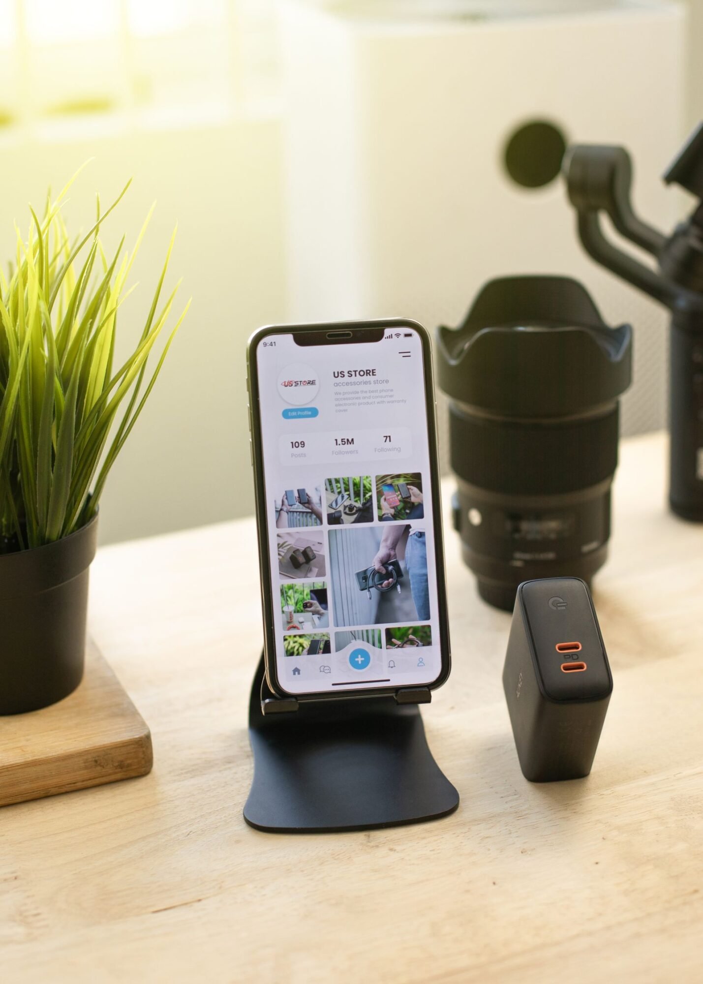 Móvil moderno en un soporte sobre un escritorio junto a otros gadgets