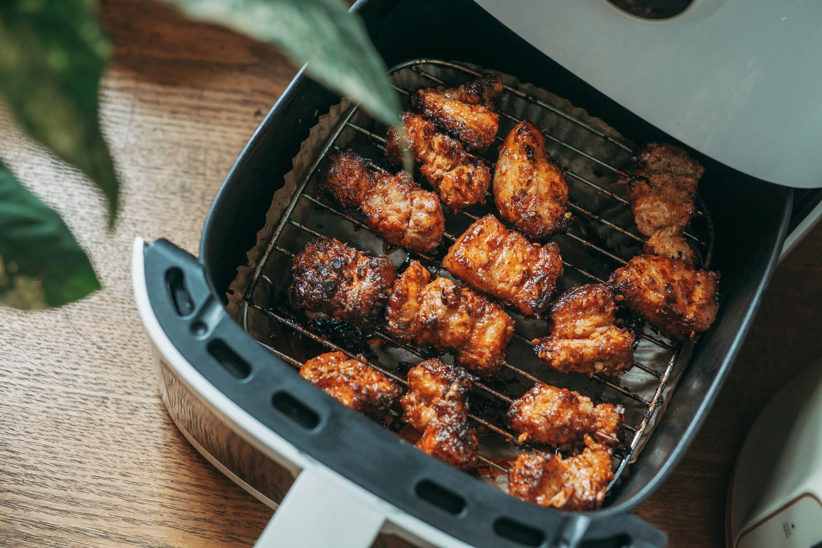 Pollo cocinado en la cesta de una air fryer compacta