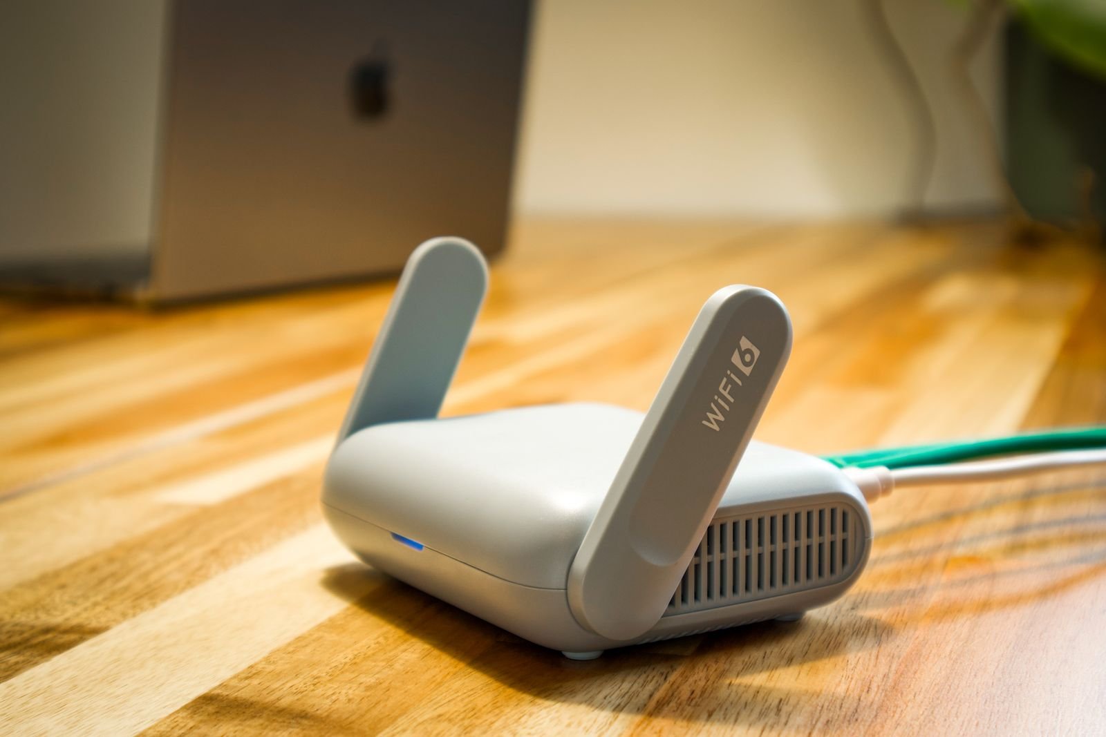 Router WiFi moderno sobre un escritorio de madera. SAI Doméstico

