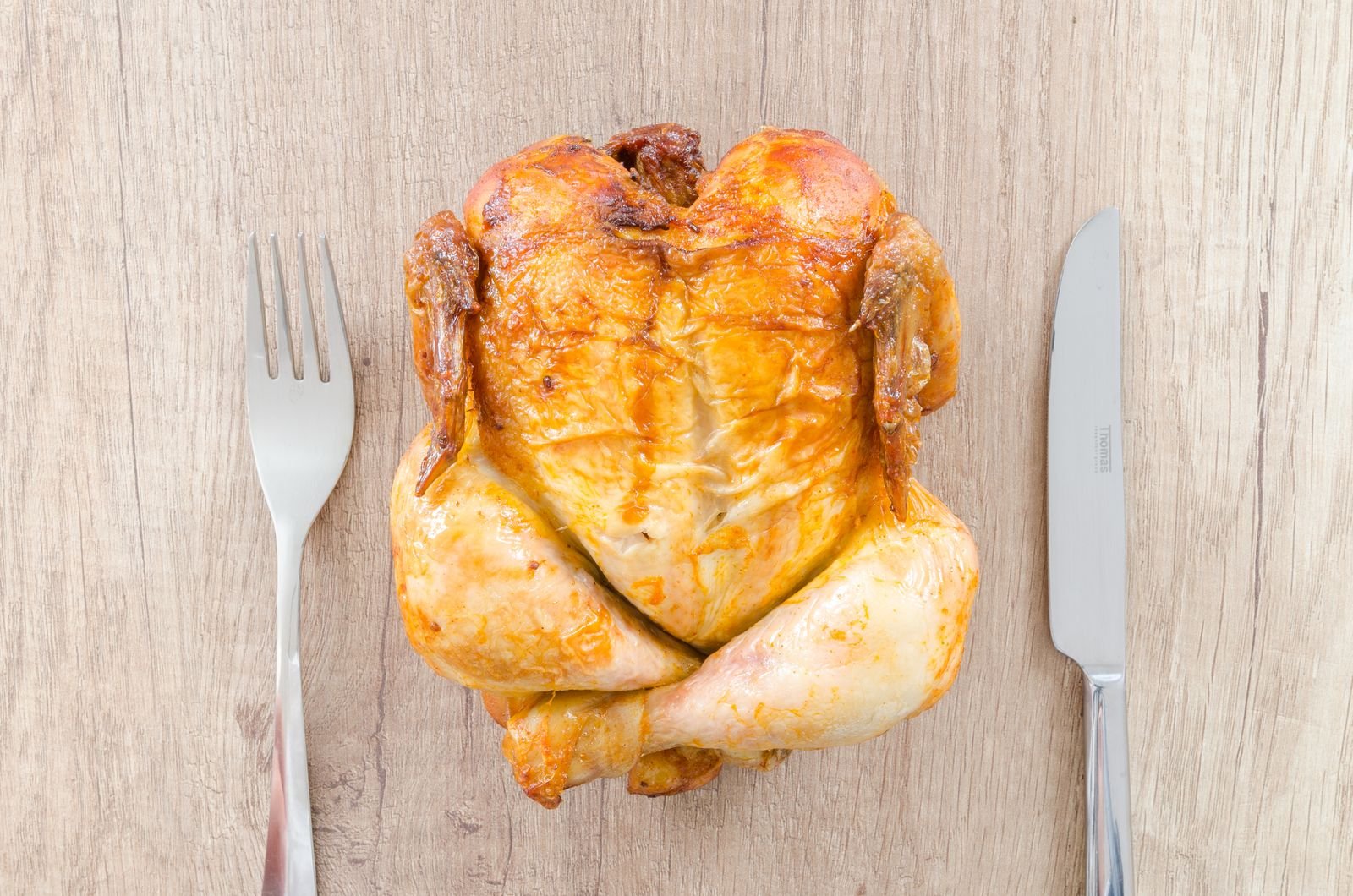 Pollo entero asado sobre una mesa de madera