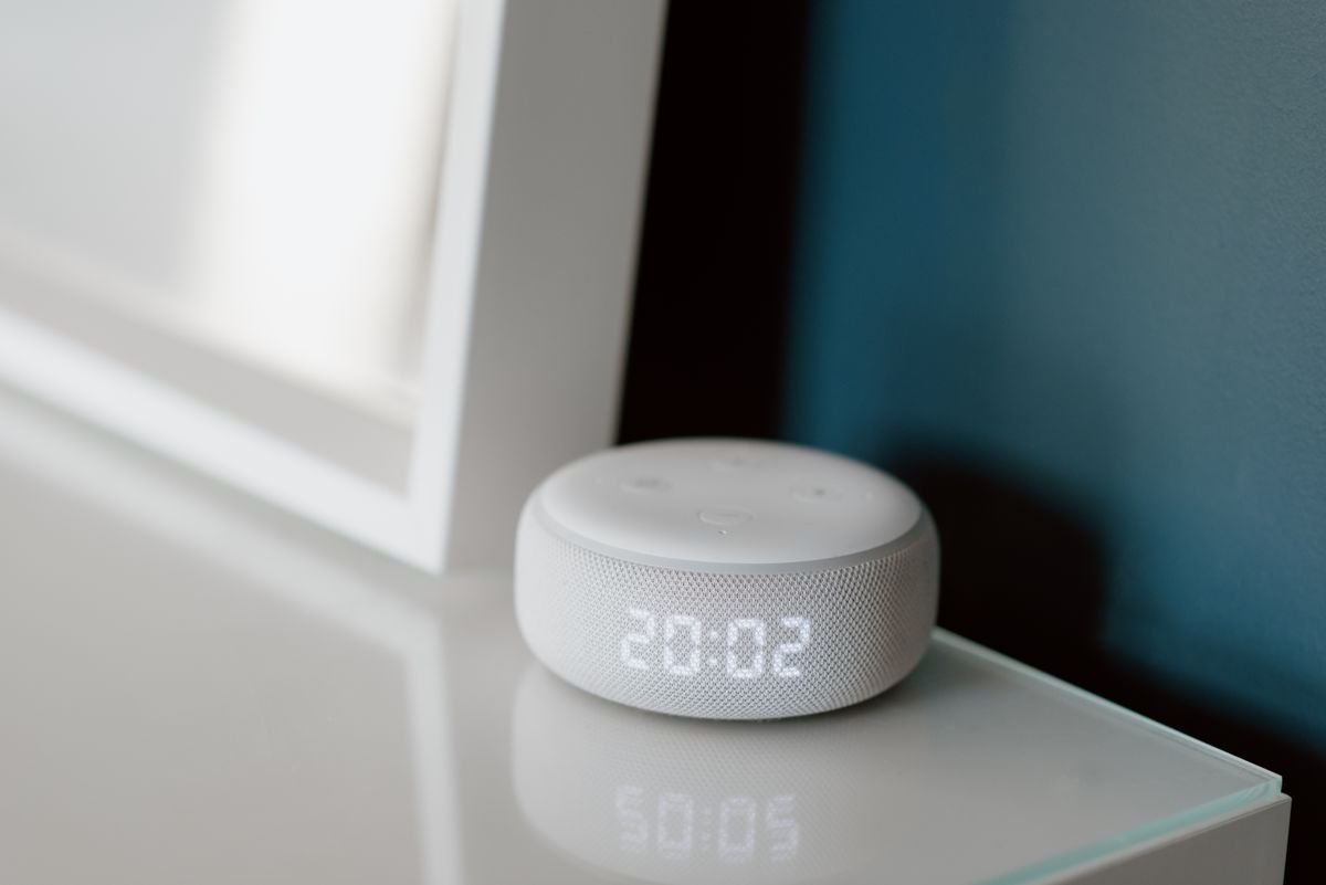 Altavoz inteligente con reloj luminoso en un escritorio