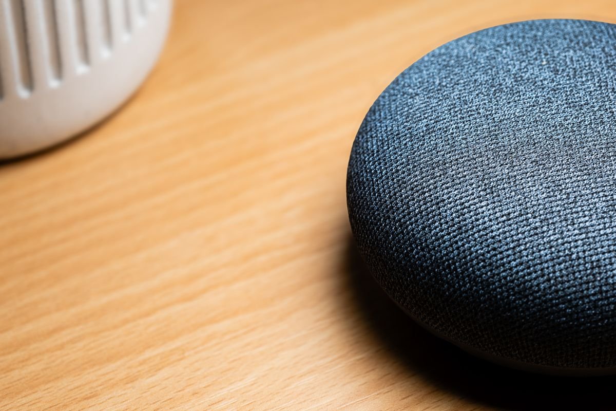Primer plano de un altavoz inteligente sobre una mesa de madera