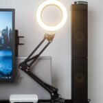 Aro de luz LED cálido iluminando un escritorio junto a un monitor