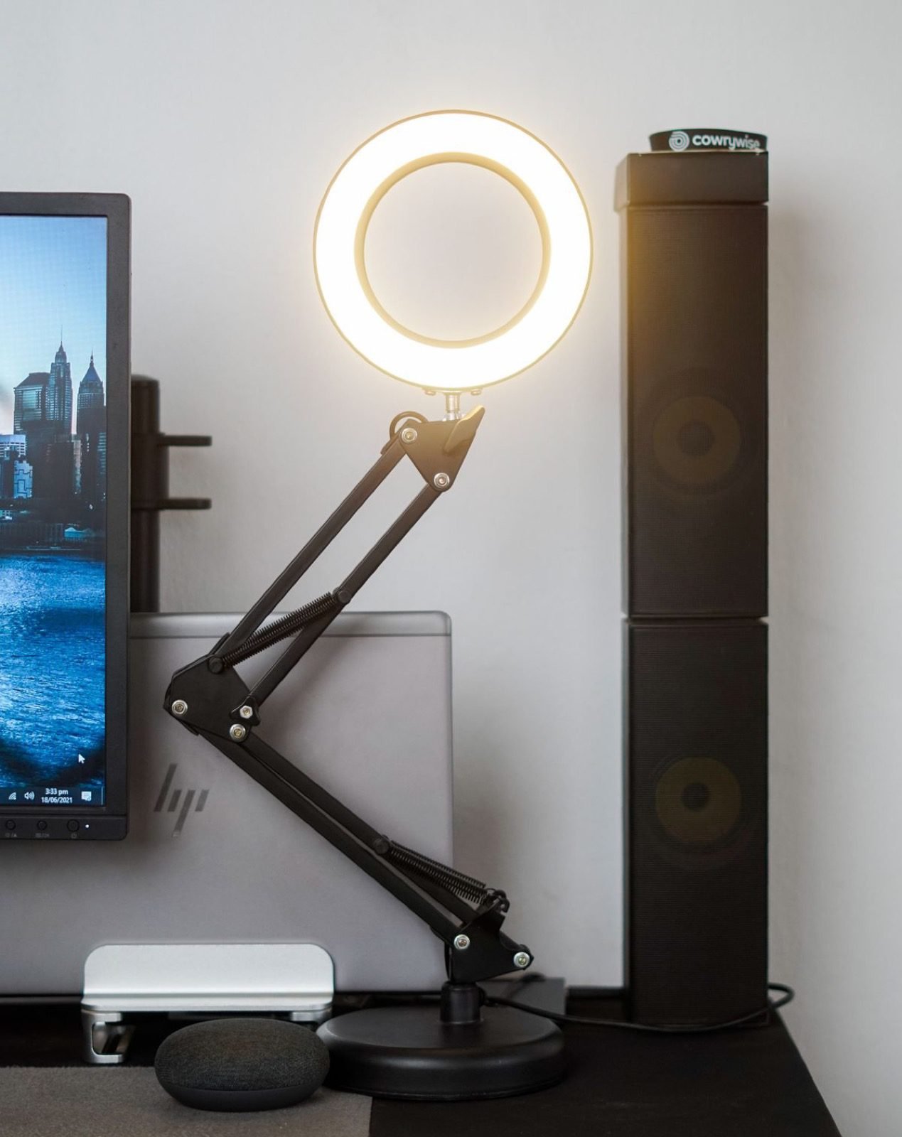 Aro de luz LED cálido iluminando un escritorio junto a un monitor