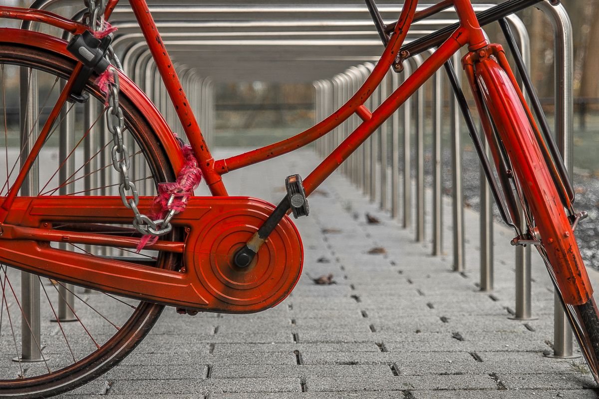 Bicicleta roja aparcada junto a una barandilla
