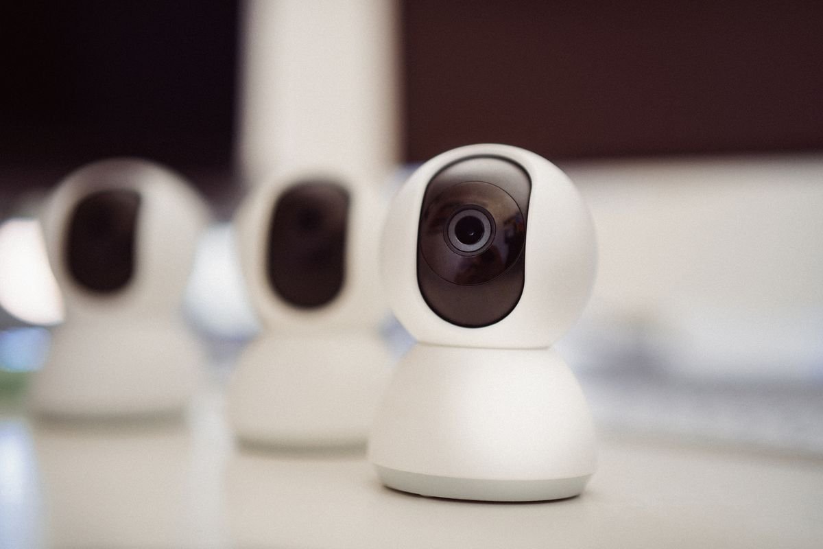 Tres cámaras inteligentes de seguridad sobre un escritorio blanco