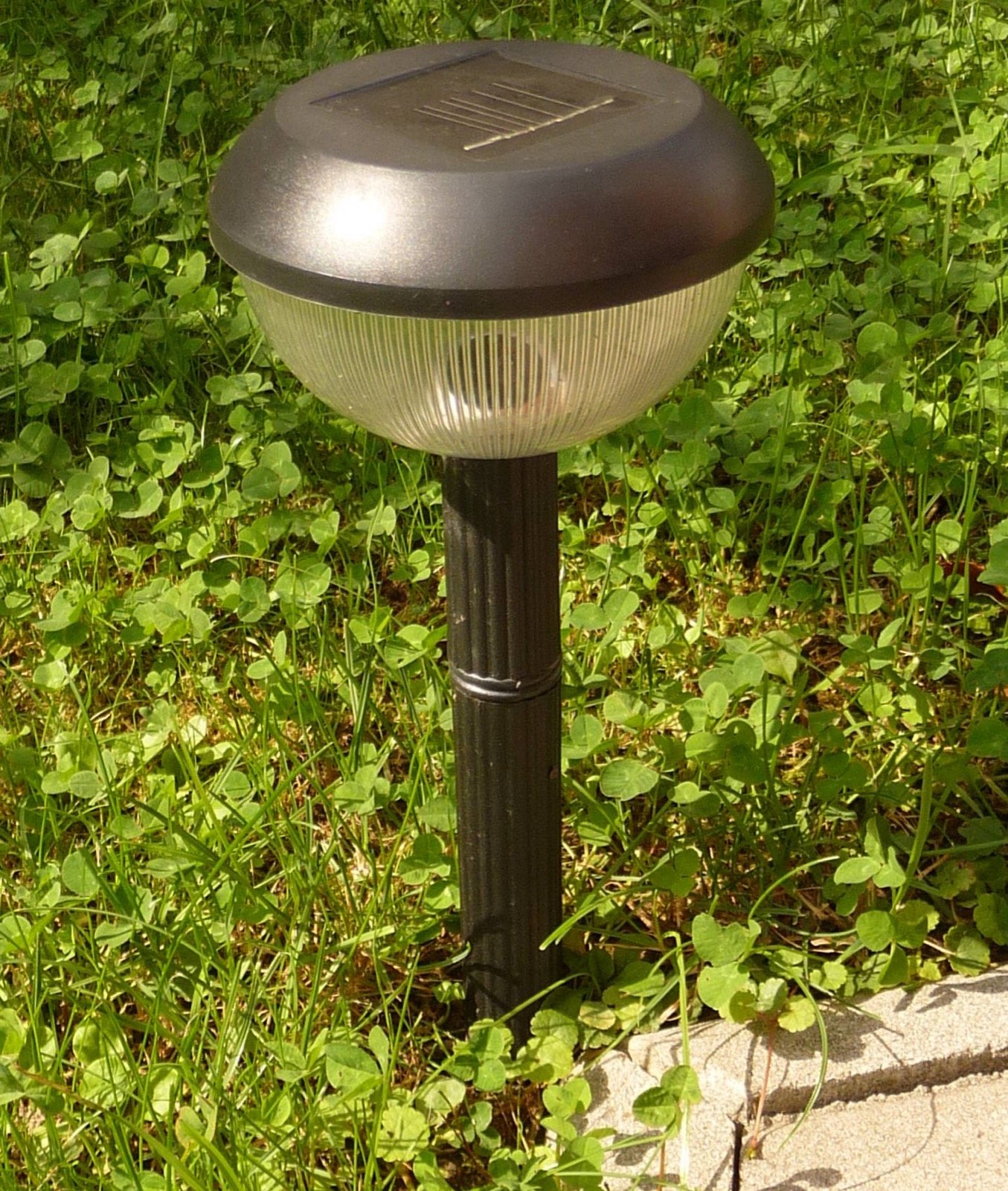 Luz solar de jardín con panel integrado clavada en el césped