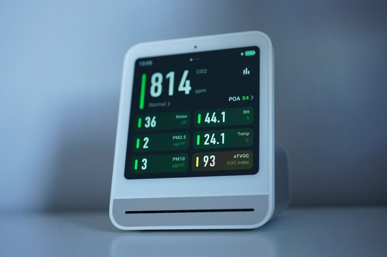 Monitor de calidad de aire mostrando niveles de CO2 en pantalla sobre un escritorio