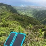 Panel solar plegable portátil usado durante una ruta de senderismo en montaña