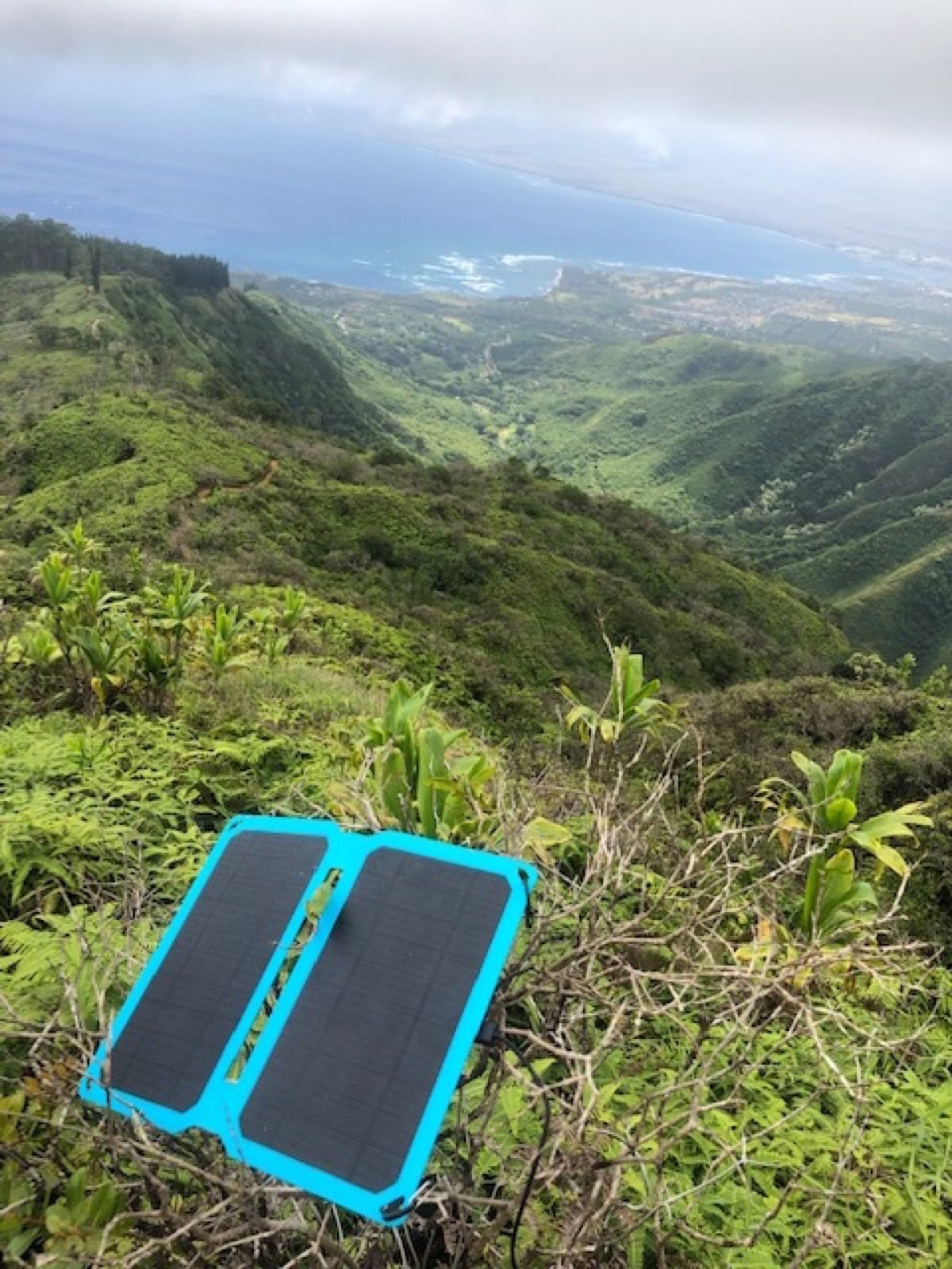 Panel solar plegable portátil usado durante una ruta de senderismo en montaña