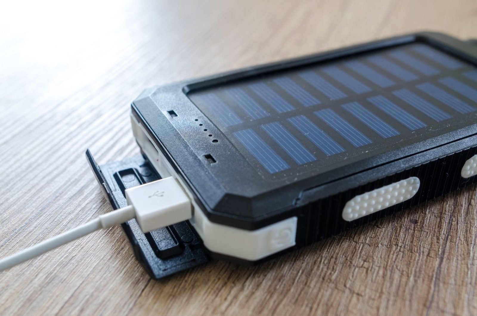 Power bank con panel solar integrado cargando un móvil por USB