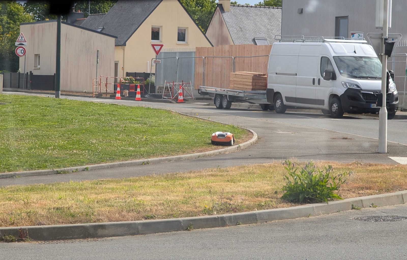 Robot cortacésped funcionando sin vigilancia en una zona ajardinada exterior
